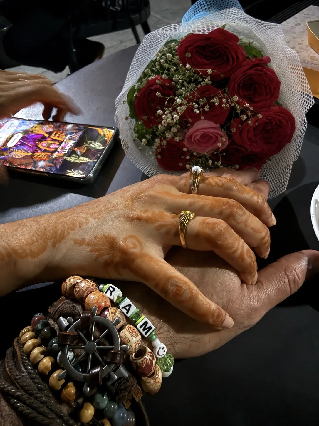 Our hands together with rings and roses